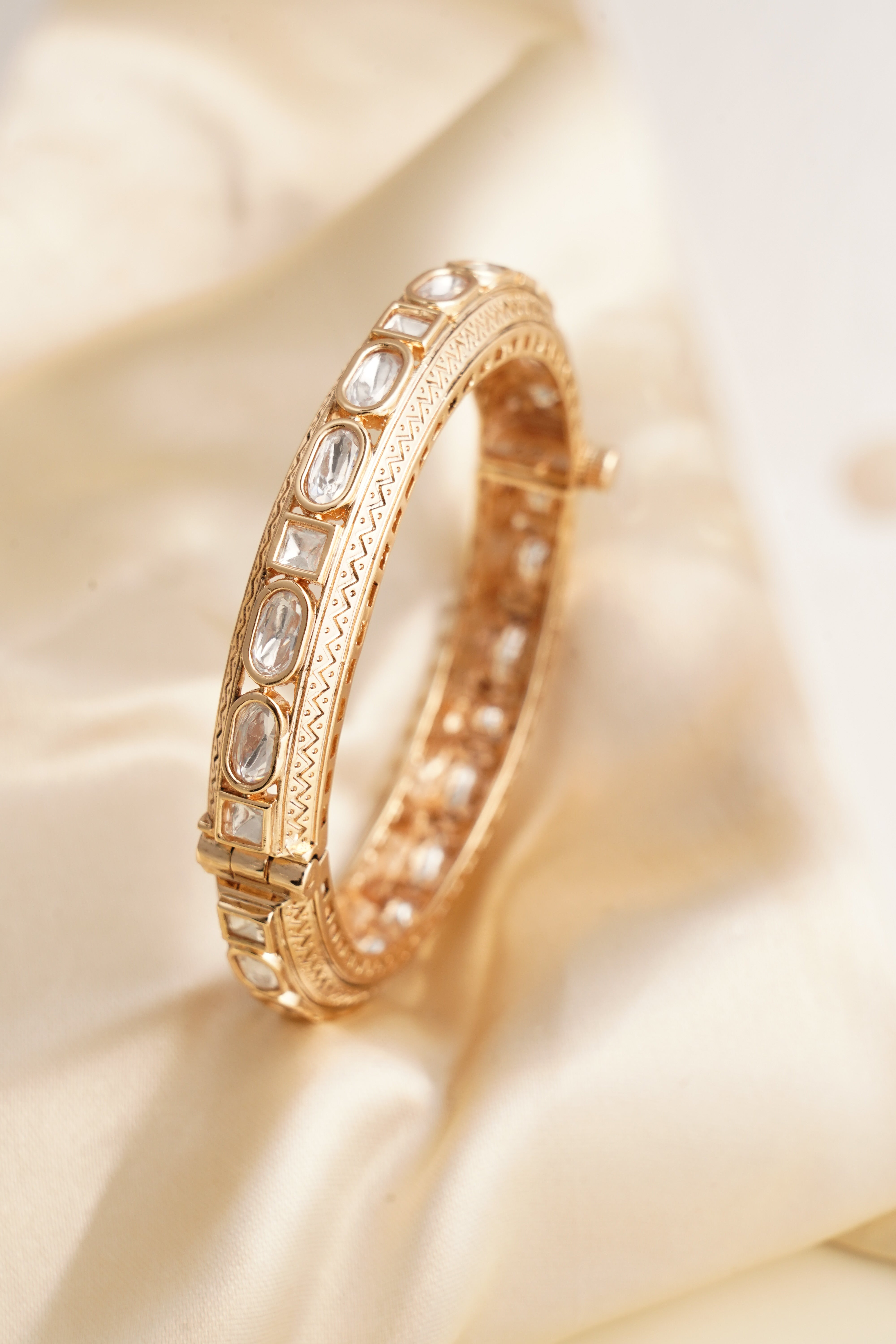 Side view of polki antique bangle showing etched detailing and alternating uncut stones